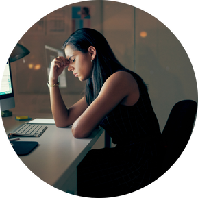 Photo of a women sitting at a desk looking stressed